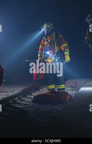 Pompier illumine les voies avec une torche, une atmosphère nocturne, un exercice incendie dans le nouveau tunnel du chemin de fer Hermann Hesse, Ostelsheim, quartier de Banque D'Images
