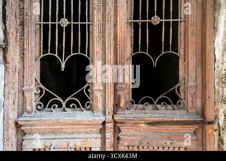 Grilles de fenêtre en fer forgé ornées en forme de coeur sur porte en bois vieilli Banque D'Images
