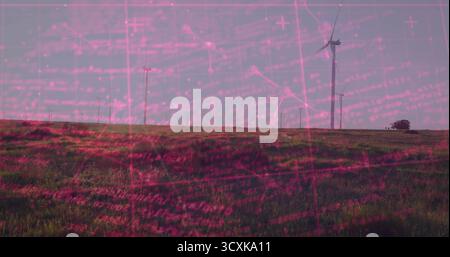 Grandes éoliennes blanches debout tournant sur un parc éolien de colline herbeuse avec des arbres lointains Banque D'Images