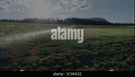 Pulvériser le système d'irrigation à pivot central arrosant les cultures sur les terres agricoles rurales, avec un brouillard d'eau fin Banque D'Images
