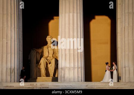 Washington DC, États-Unis. 15 octobre 2025. Une mariée et un marié se font prendre en photo au lever du soleil au Lincoln Memorial. Crédit : Kay Nietfeld/dpa/Alamy Live News Banque D'Images