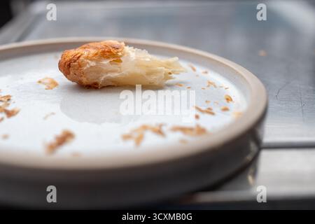 croissant à moitié mangé sur une plaque blanche peu profonde Banque D'Images