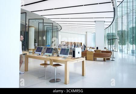 Intérieur moderne d'Apple Store à Dubai Mall UAE avec un design élégant, des clients naviguant sur des produits technologiques et une rangée d'ordinateurs iMac exposés Banque D'Images