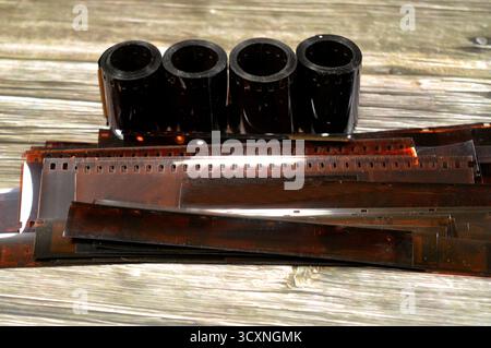 plusieurs rouleaux de film de 35 mm et des bandes de négatifs de film développé, le film photographique est une feuille de plastique enduite d'une émulsion sensible à la lumière cont Banque D'Images