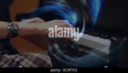 Jouer les mains du pianiste se déplaçant sur le clavier de piano au studio de musique, avec manchette métallique, jupe à carreaux Banque D'Images