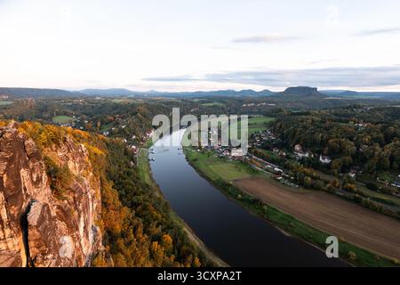 Paysage de la Suisse saxonne au coucher du soleil. Belle nature en Allemagne de l'est pendant la saison d'automne. Montagnes de grès illuminées et rivière Elbe. Banque D'Images