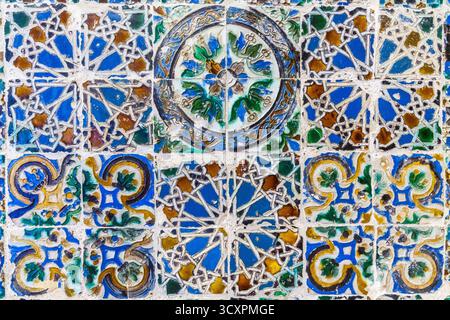 Une vue rapprochée et vibrante d'une mosaïque de carreaux de céramique traditionnelle présentant une riche gamme de motifs géométriques et floraux dans des tons bleus, verts et terreux Banque D'Images