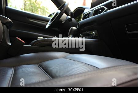 Vue depuis le bas du siège passager du tunnel flou entre les sièges, le levier de changement de vitesse et le volant à l'intérieur de la voiture avec un in coûteux Banque D'Images