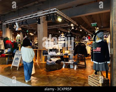 Manchester, Royaume-Uni - 26 septembre 2025 : une boutique de mode Tribe Vintage animée présentant des tenues vintage et modernes dans un espace commercial chaleureusement éclairé. Banque D'Images