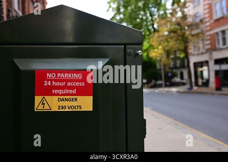 Londres, Royaume-Uni, 7 octobre 2025. Panneau indiquant « stationnement interdit » et « danger 230 volts » sur un coffret électrique à Kensington. Banque D'Images