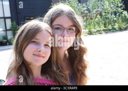 Les filles assises sur le scooter à moteur Vespa Banque D'Images