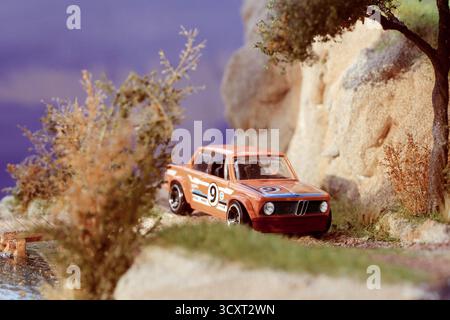 Diorama miniature très détaillé mettant en vedette une voiture de course BMW 2002 1969 classique dans un cadre extérieur dynamique. Banque D'Images