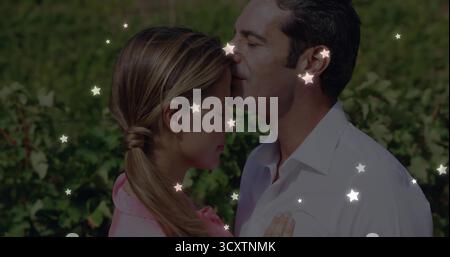 Partage front baiser homme doucement pressant les lèvres sur la femme dans les rangées de vignobles luxuriantes avec des lumières d'étoile Banque D'Images