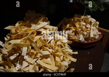 Tas dorés de pâtes romaines fettuccine (ou Tagliatelle) artisanales, prêtes à être cuites. Authentique tradition culinaire italienne. Banque D'Images