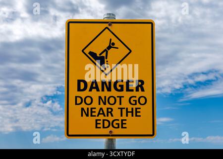Un signe contre le ciel montrant le danger - ne pas aller près du bord Banque D'Images