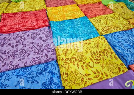 Sélection colorée de vêtements en tissu de bambou pliés et exposés dans une boutique de cadeaux. Kuta, Bali, Indonésie. Banque D'Images