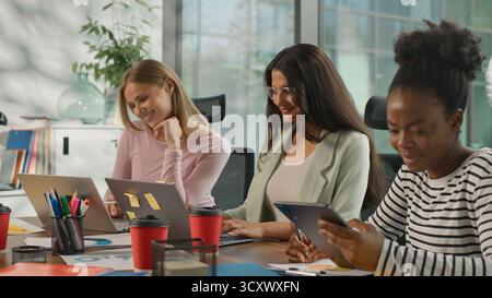 Trois femmes d'affaires informelles multiraciales travaillant dans le bureau occasionnel diversité femmes d'affaires travaillent avec des ordinateurs portables collaboration de partenariat informatique Banque D'Images