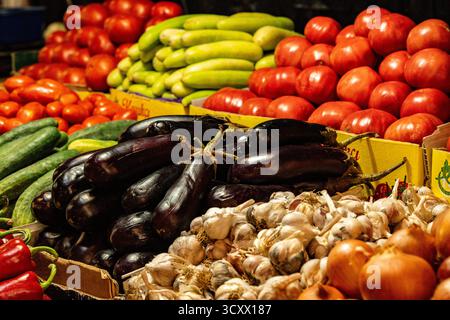Légumes frais colorés exposés sur les étals du marché à Kutaisi Géorgie : tomates, poivrons, aubergines, oignons et concombres symbolisant la récolte locale Banque D'Images