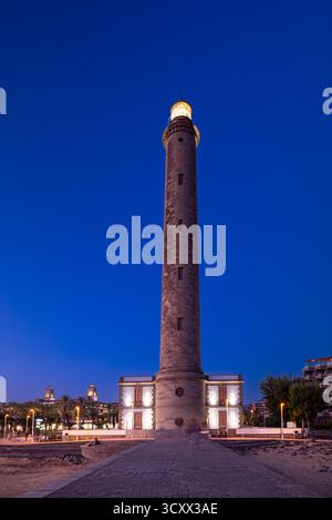 Une vue imprenable sur le phare historique de Maspalomas sur Gran Canaria au crépuscule, illuminé dans un ciel bleu profond. Le monument emblématique se dresse haut ne Banque D'Images