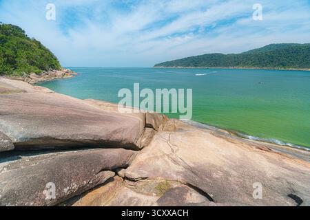 Plage de Guaiuba, Guaruja SP, Brésil. Journée ensoleillée sur la petite baie avec mer tranquille. Image des loisirs et du tourisme sur la côte de Sao Paulo. Collines couvertes Banque D'Images