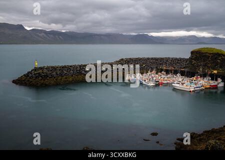 La scène tranquille des bateaux de pêche amarrés dans le port d'Arnarstapi Banque D'Images