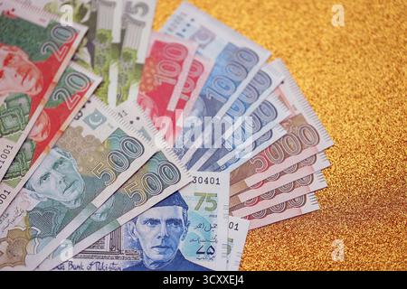 Pakistan roupies billets de banque sur fond jaune doré. Les factures d'argent pakistanaises actuelles sont sur la table en gros montant. Le concept d'affaires et d'investissement au Pakistan Banque D'Images