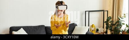 Une fille explore avec impatience un monde virtuel tout en portant un casque VR à la maison, bannière Banque D'Images