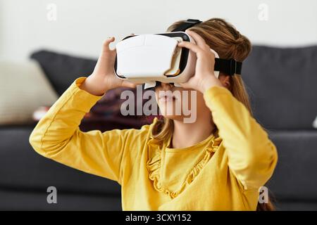 Fille immergée dans le divertissement de réalité virtuelle, gen alpha Kid Banque D'Images