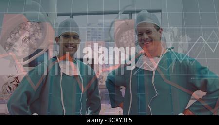 Deux chirurgiens masculins debout dans des gommages sous des plafonniers près de fenêtres OU, avec des superpositions de données Banque D'Images