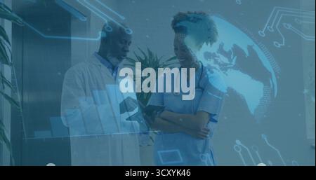 Deux membres du personnel médical examinant la tablette dans le couloir de l'hôpital, avec cartes holographiques et stéthoscope Banque D'Images