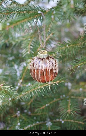 Gros plan d'une boule de Noël brun en verre transparent sur un arbre de Noël Banque D'Images