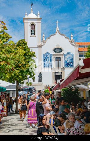Aviero, Portugal : 15 août 2023 : vue de face d'une église blanche à Aveiro avec des touristes et des terrasses de café en face sous le ciel lumineux de l'été. Banque D'Images