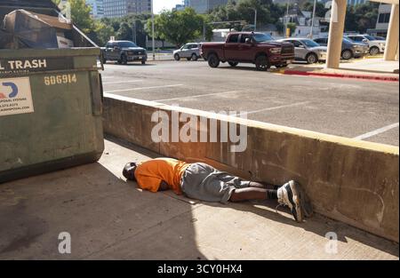 Un sans-abri semble dormir tard le matin dans une ruelle à une courte distance du manoir du gouverneur du Texas en arrière-plan le 11 octobre 2025. Les dirigeants d'Austin continuent d'essayer de nouvelles solutions pour aider sa population de sans-abri qui luttent quotidiennement pour trouver un abri, de la nourriture et des vêtements dans le centre urbain d'Austin. Banque D'Images