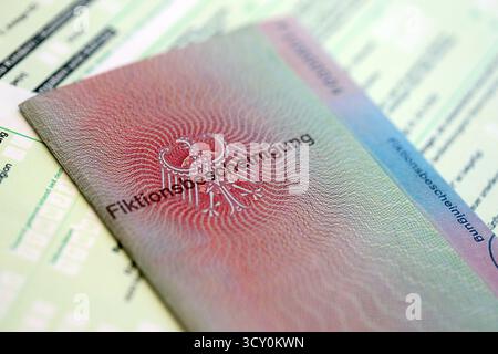 Le spécimen de carte de résident permanent temporaire allemand se trouve sur le formulaire fiscal allemand close up. Fiktionsbescheinigung et einkommensteuerklarung Banque D'Images