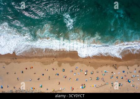 Photo aérienne drone de touristes et de parasols sur la plage de sable. Vue de haut en bas des gens profitant des vacances d'été par la mer sur la journée ensoleillée Banque D'Images