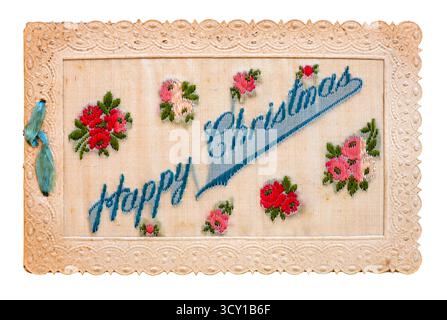 WW ! Carte de voeux de Noël brodée en soie 'joyeux Noël' parmi plusieurs fleurs rouges. Banque D'Images