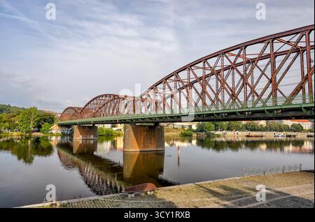Pont ferroviaire de Vyšehrad sur la rivière Vltava à Prague, République tchèque, avec des fermes d'acier reflétées dans l'eau calme. Banque D'Images