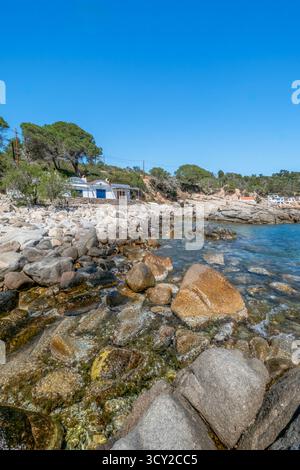 Vue verticale époustouflante du littoral rocheux accidenté et de l'eau turquoise transparente, avec des cabanes de pêcheurs traditionnelles blanchies à la chaux nichées au milieu de Banque D'Images