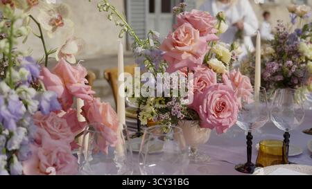 Table de réception de mariage décorée de roses et d'orchidées. Action Banque D'Images
