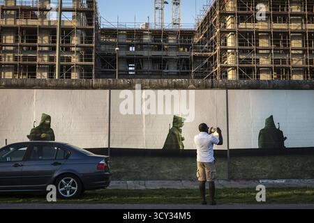 DEU Allemagne Berlin Un touriste prend une photo sur son téléphone portable de l'installation 'Beyond the Wall' de l'artiste Stefan Roloff à la Eastside Galery Banque D'Images