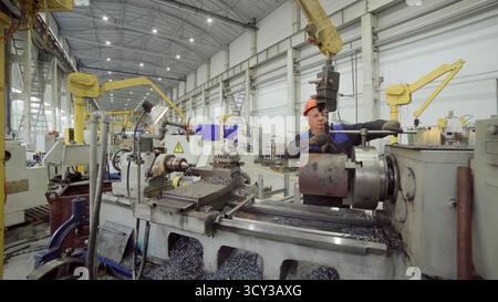 Ouvrier d'usine utilisant la machine de tour dans l'usine de fabrication. Pince de stock Banque D'Images