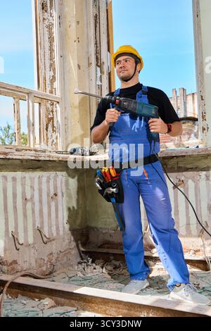 Travailleur de la construction utilisant de l'équipement dans un bâtiment rénové Banque D'Images