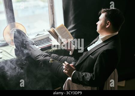 Homme lisant livre en costume par fenêtre avec fumée et machine à écrire Banque D'Images