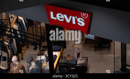 Cracovie, Pologne, octobre 2025. Vue intérieure d'un magasin Lévis présentant des jeans en Jean pliés, des vestes et des mannequins dans des tenues décontractées sous l'illumin Banque D'Images