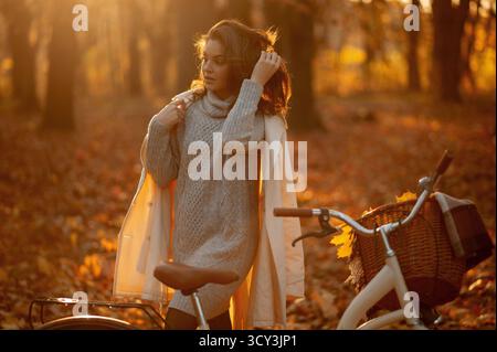 Portrait de belle femme avec de longs cheveux debout près de son vélo Banque D'Images