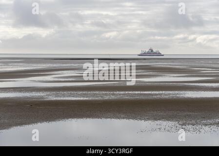 Un ferry du Wyker Dampfschiffs-Reederei (W.D.R.) navigue à marée basse dans la mer des Wadden entre Foehr et le continent, Schleswig-Holstein, Allemagne Banque D'Images