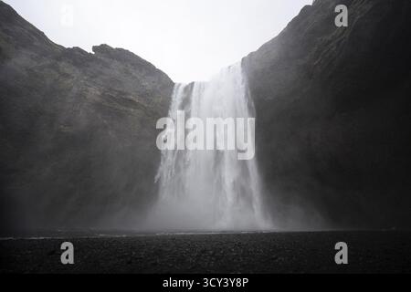 Vue sur l'eau glacée plongeant des falaises sombres, la brume tourbillonnante voilant la scène d'une beauté éthérée, une symphonie de la puissance brute de la nature, Reykjavik, Islande. Banque D'Images