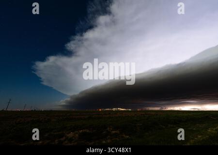 La foudre se cache sous les nuages bruyants au-dessus de la campagne silencieuse, avec un ciel dramatique, une atmosphère sombre, de l'ombre et de la texture Banque D'Images