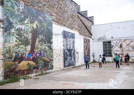 Vue d'une exposition en plein air au Festival photo la Gacilly avec de grandes tirages photographiques sur les murs et des personnes observant les œuvres d'art à la Gacill Banque D'Images