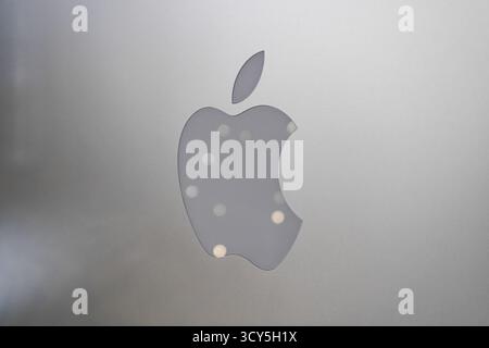 Logo d'Apple vu sur le dos de l'ordinateur iMac argenté avec réflexion des lumières Banque D'Images